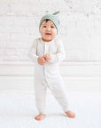 Baby traegt Klassische Knotenmuetze in Thymian
