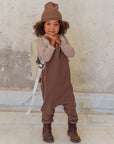 Ein Kind, das ein 3er-Set Natural Waffle Overall + Pullover + Mütze in Braun trägt