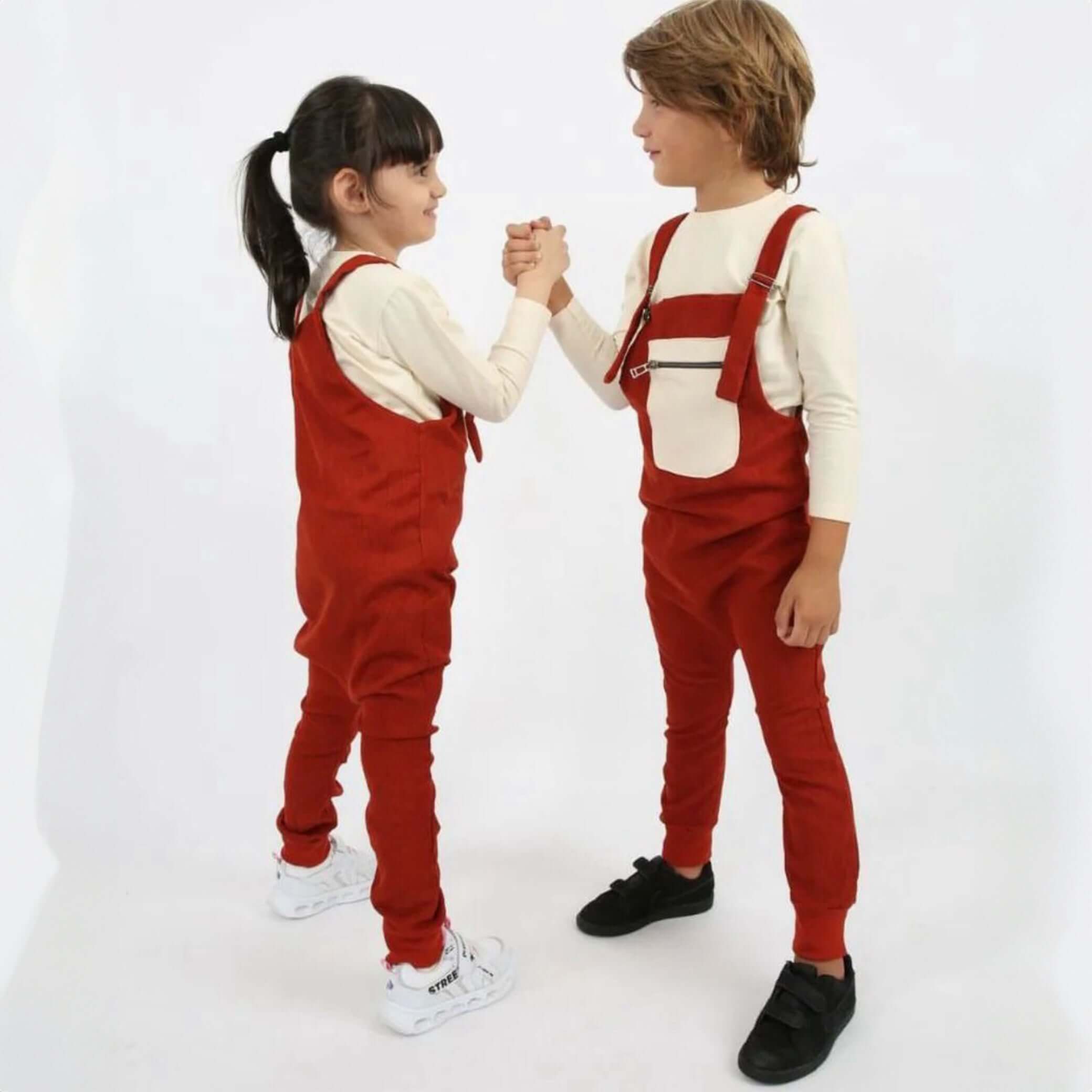 Ein Junge und ein Mädchen tragen ein 2-teiliges Set „Velved Collection“ Overall + Sweatshirt in Rot