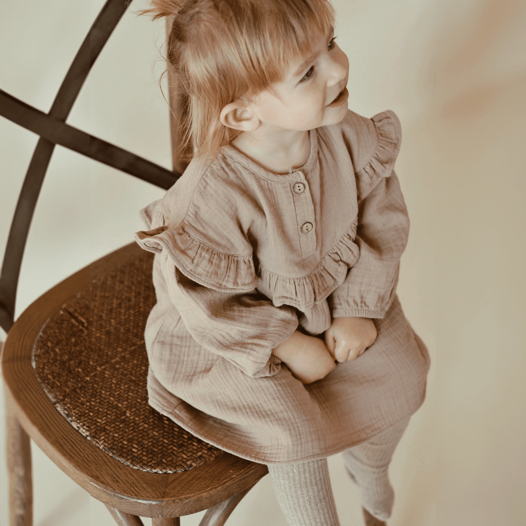 Eine Nahaufnahme eines kleinen glücklichen Mädchens, das ein Nehru-Kleid aus Bio-Baumwolle trägt.