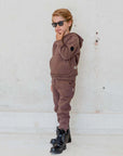 Ein Kind trägt 3-Thread-Fleece Trainingsanzug in Braun