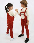Ein Junge und ein Mädchen tragen ein 2-teiliges Set „Velved Collection“ Overall + Sweatshirt in Rot