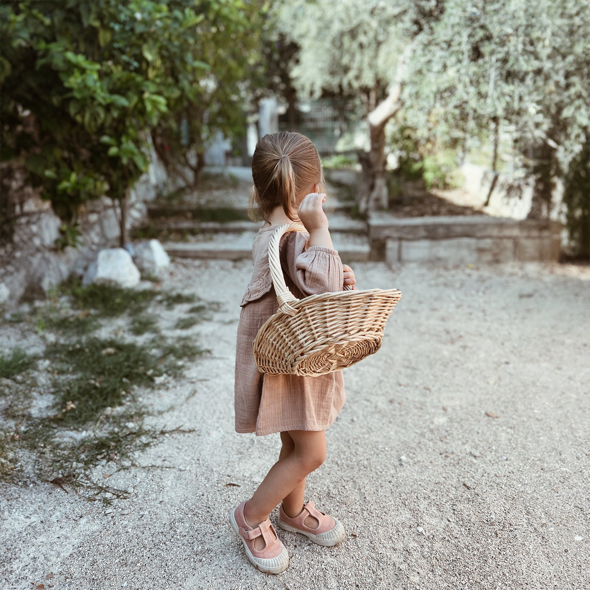 Ein süßes Mädchen, das draußen ein Nehir-Kleid aus Bio-Baumwolle trägt