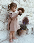 ein süßes Mädchen im Nehir-Kleid aus Bio-Baumwolle