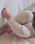 ein Baby, das Bio-PEPA-Leggings in Beige trägt