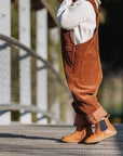 ein Kind, das Axelle Lauflernschuhe in Braun /Marine trägt