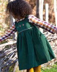 Kind Trägt Besticktes Toadstool Cord Pinny Kleid 