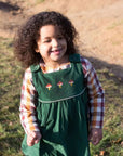 Glückliches Kind trägt Besticktes Toadstool Cord Pinny Kleid