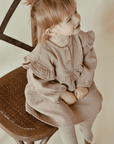 Eine Nahaufnahme eines kleinen glücklichen Mädchens, das ein Nehru-Kleid aus Bio-Baumwolle trägt.