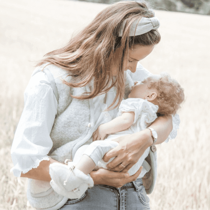 Ein Baby trägt die Baby Hauschuhe aus 100 % Wolle in Naturfarbe